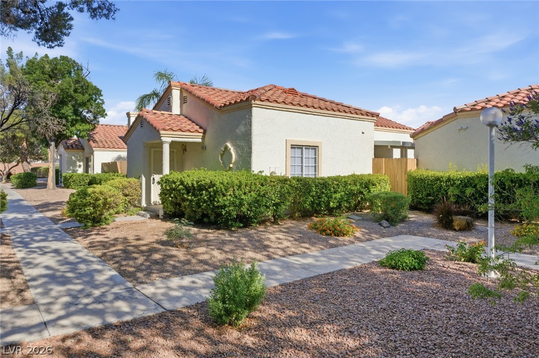 5449 Bugle Way, Unit 104 Las Vegas, NV 89108 - Photo 3 of 33 This charming home features a classic tile roof and well-maintained landscaping, perfect for peaceful living.