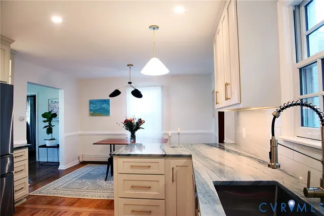 a kitchen with white cabinets and sink