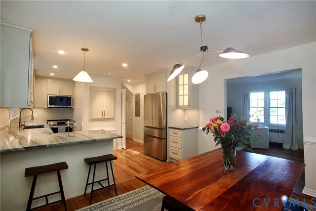 a kitchen with refrigerator and wooden floor