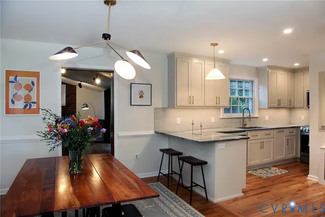 a kitchen with kitchen island granite countertop a sink cabinets and wooden floor