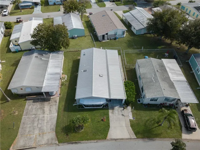 an aerial view of a house with garden space and a car parked