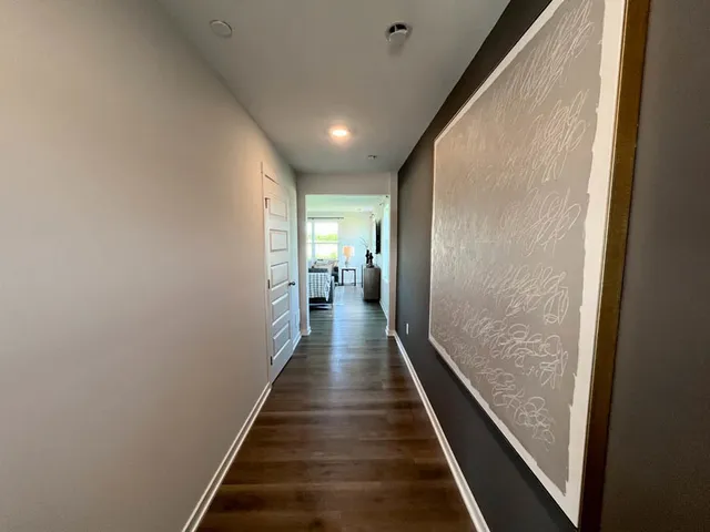 a view of a hallway with wooden floor and staircase