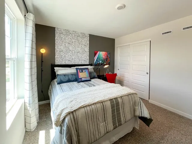 a bed sitting in a bedroom next to a window