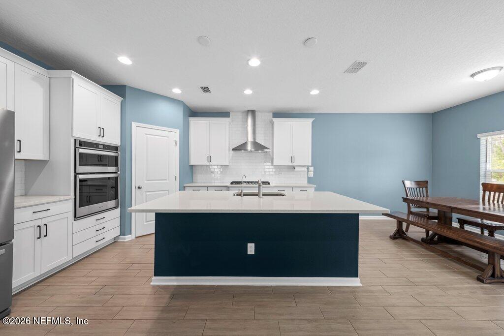 200 Starnberg Ct Street St. Augustine, FL 32095 - Photo 35 of 48 a kitchen with kitchen island stainless steel appliances a sink a stove cabinets and wooden floor