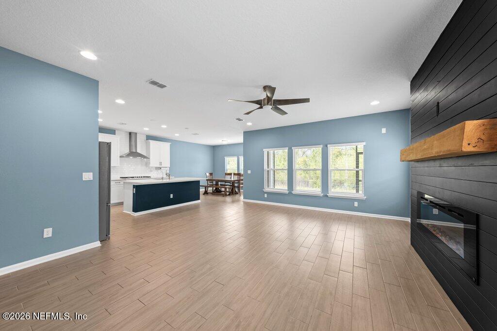 200 Starnberg Ct Street St. Augustine, FL 32095 - Photo 41 of 48 a view of kitchen and empty room with wooden floor and fireplace