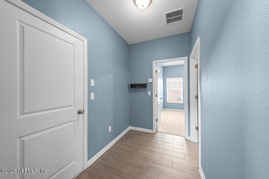 200 Starnberg Ct Street St. Augustine, FL 32095 - Photo 10 of 48 a view of a hallway with wooden floor and a bathroom
