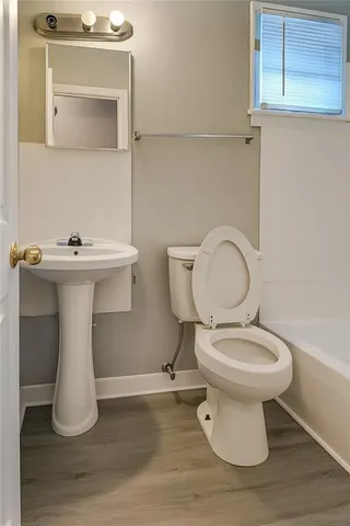 a bathroom with a toilet sink and mirror
