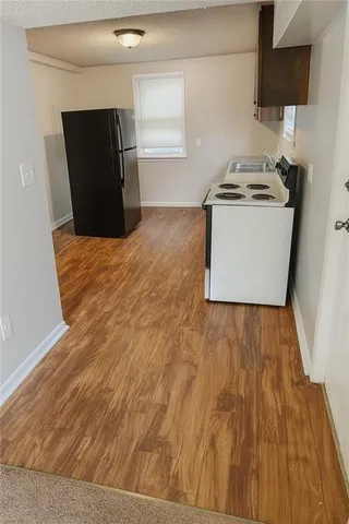 a kitchen with a wooden floor and a stove top oven
