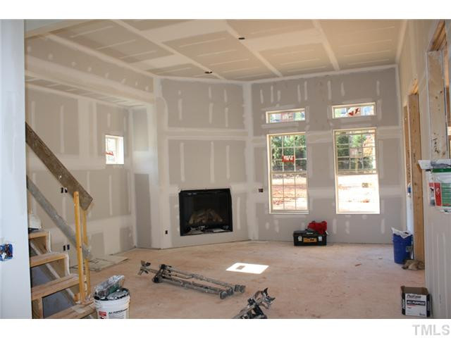 Corner fireplace, huge wall of built-ins, 11' ceiling will feature coffered ceiling detail and 7 1/4" crown. Site finished hardwoods in family room, and stairs on left will be full oak treads with iron rail. Den/Family/Great Room