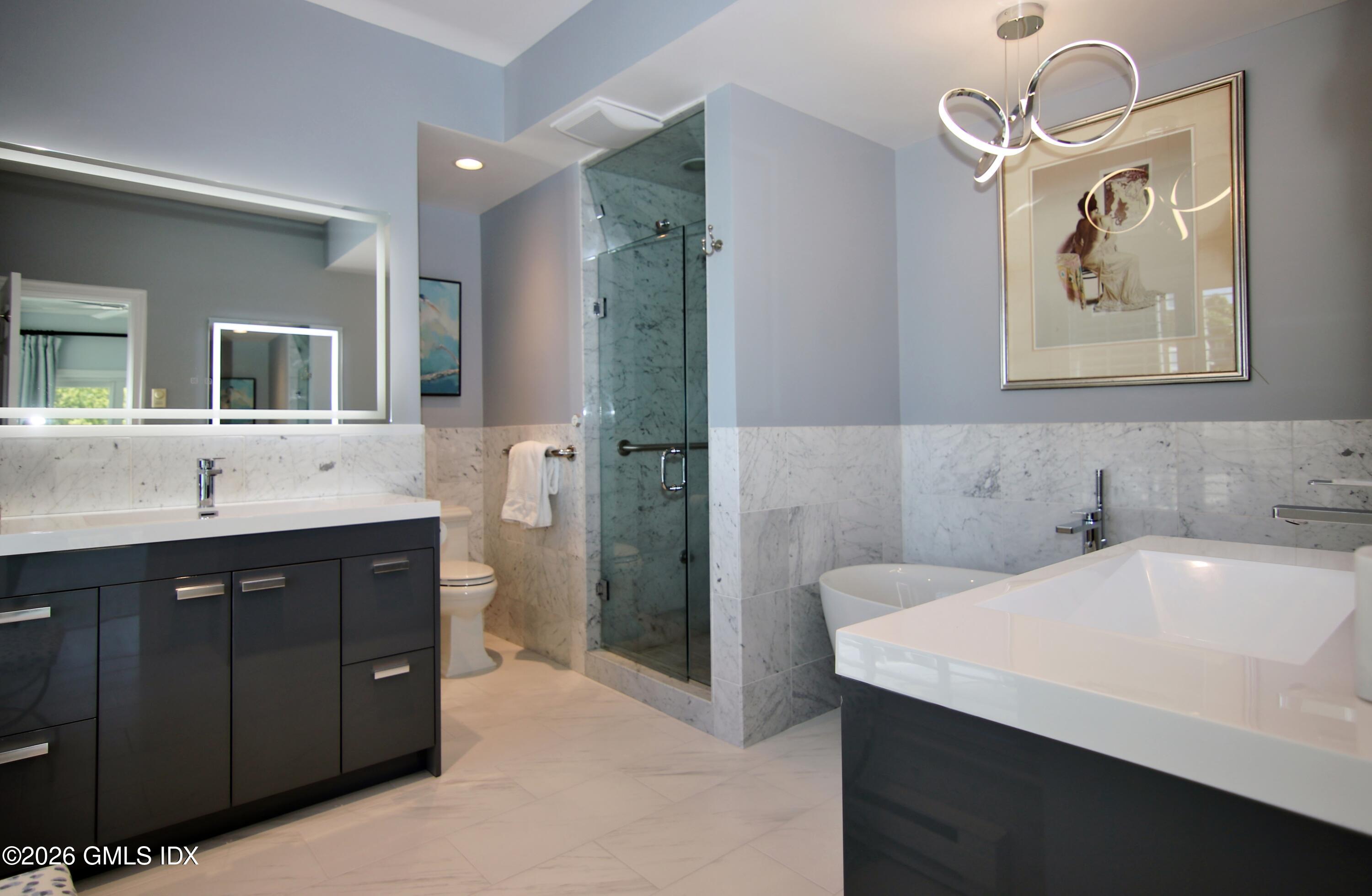 633 Steamboat Road, Unit 5 Greenwich, CT 06830 - Photo 13 of 29 a bathroom with a sink a large mirror and a bathtub