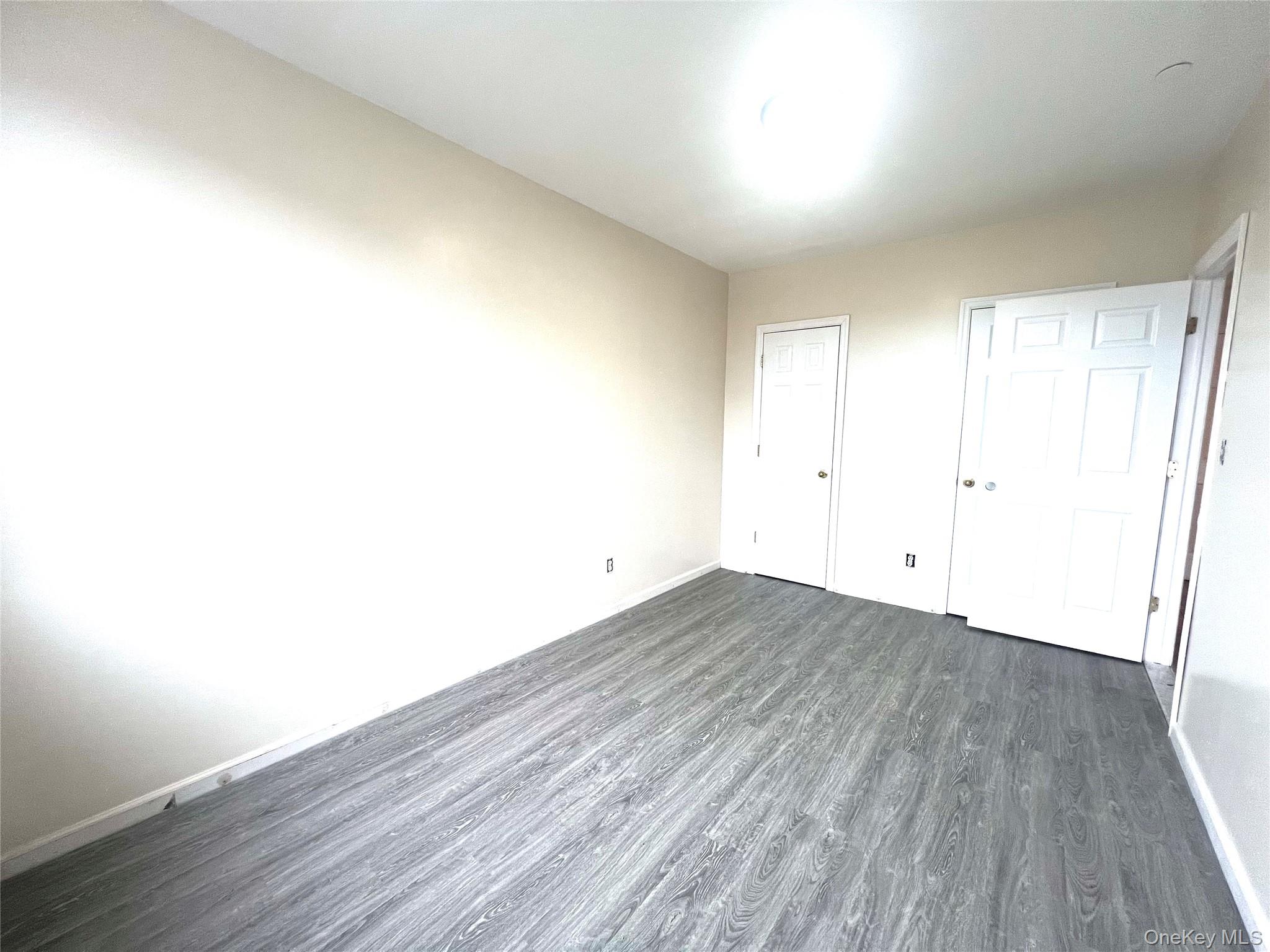 104-04 47th Avenue, Unit 2C Queens, NY 11368 - Photo 4 of 9 an empty room with wooden floor