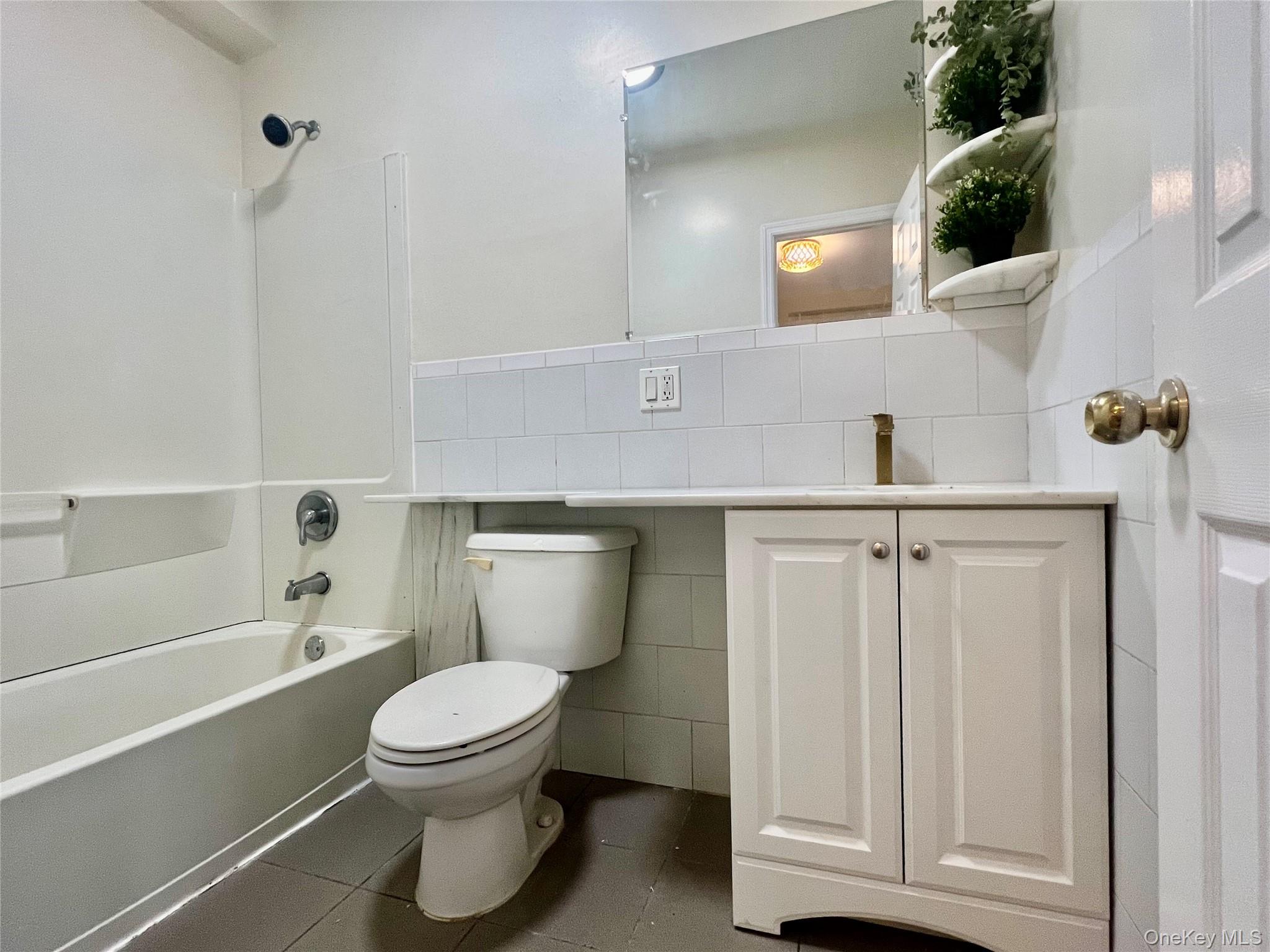 104-04 47th Avenue, Unit 2C Queens, NY 11368 - Photo 6 of 9 a bathroom with a toilet a sink and bathtub