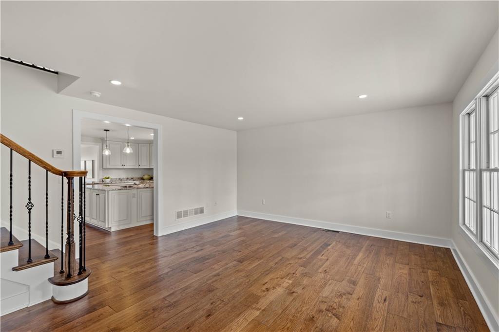 411 Georgetown Road Lawrence, PA 15055 - Photo 14 of 40 an empty room with wooden floor and a kitchen