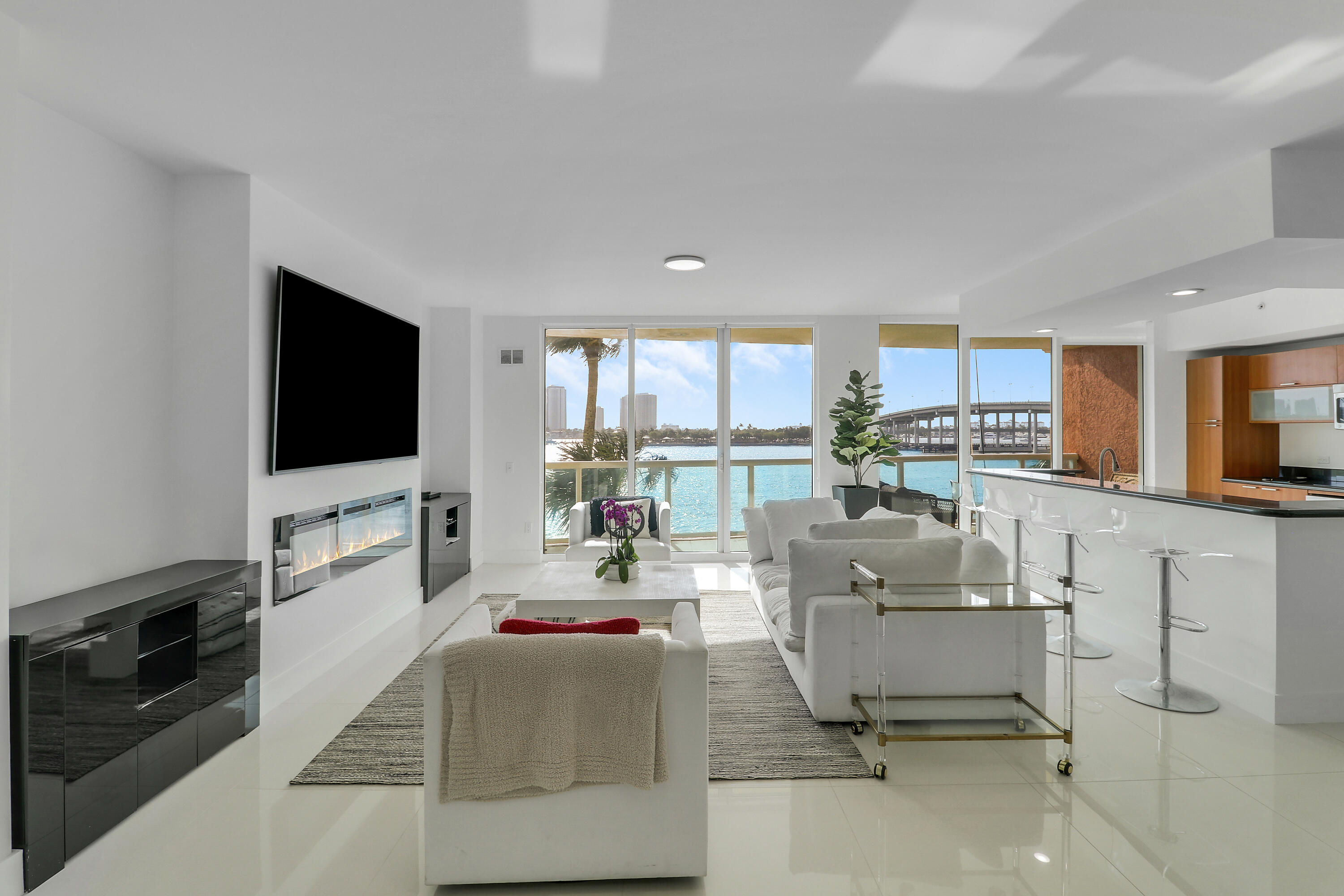 2640 Lake Shore Drive, Unit 307 Riviera Beach, FL 33404 - Photo 6 of 44 a living room with furniture and a flat screen tv
