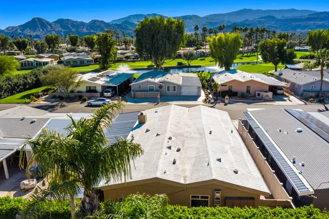 an aerial view of a house with garden space and mountain view in back