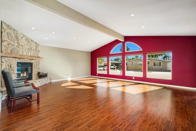 a view of empty room with wooden floor and fireplace