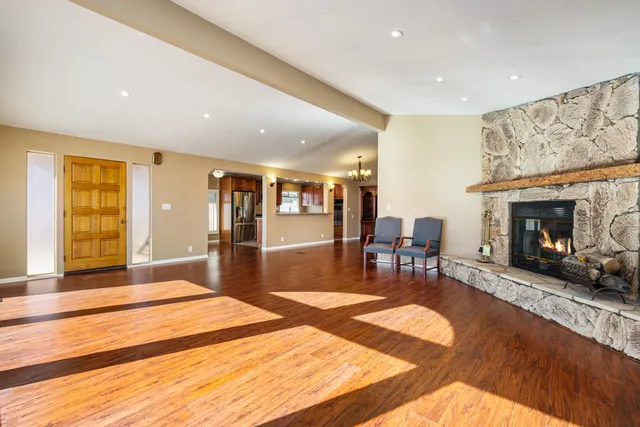 a spacious bedroom with a bed a table and a fireplace