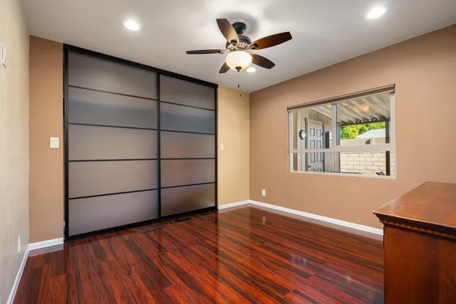 a view of a livingroom with wooden floor and a ceiling fan