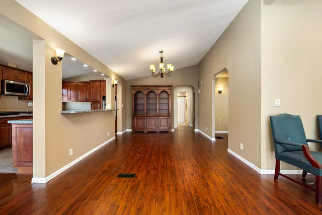 a view of a hallway with wooden floor and furniture