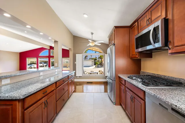 a kitchen with stainless steel appliances granite countertop a stove a sink and a microwave