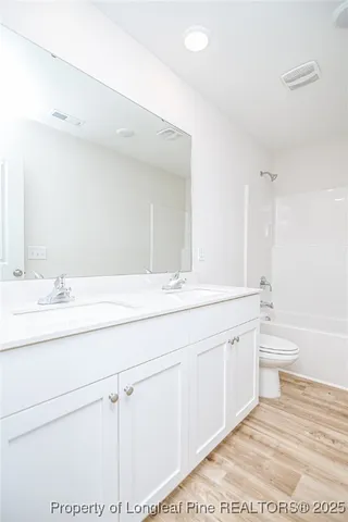a bathroom with a double vanity sink and a toilet