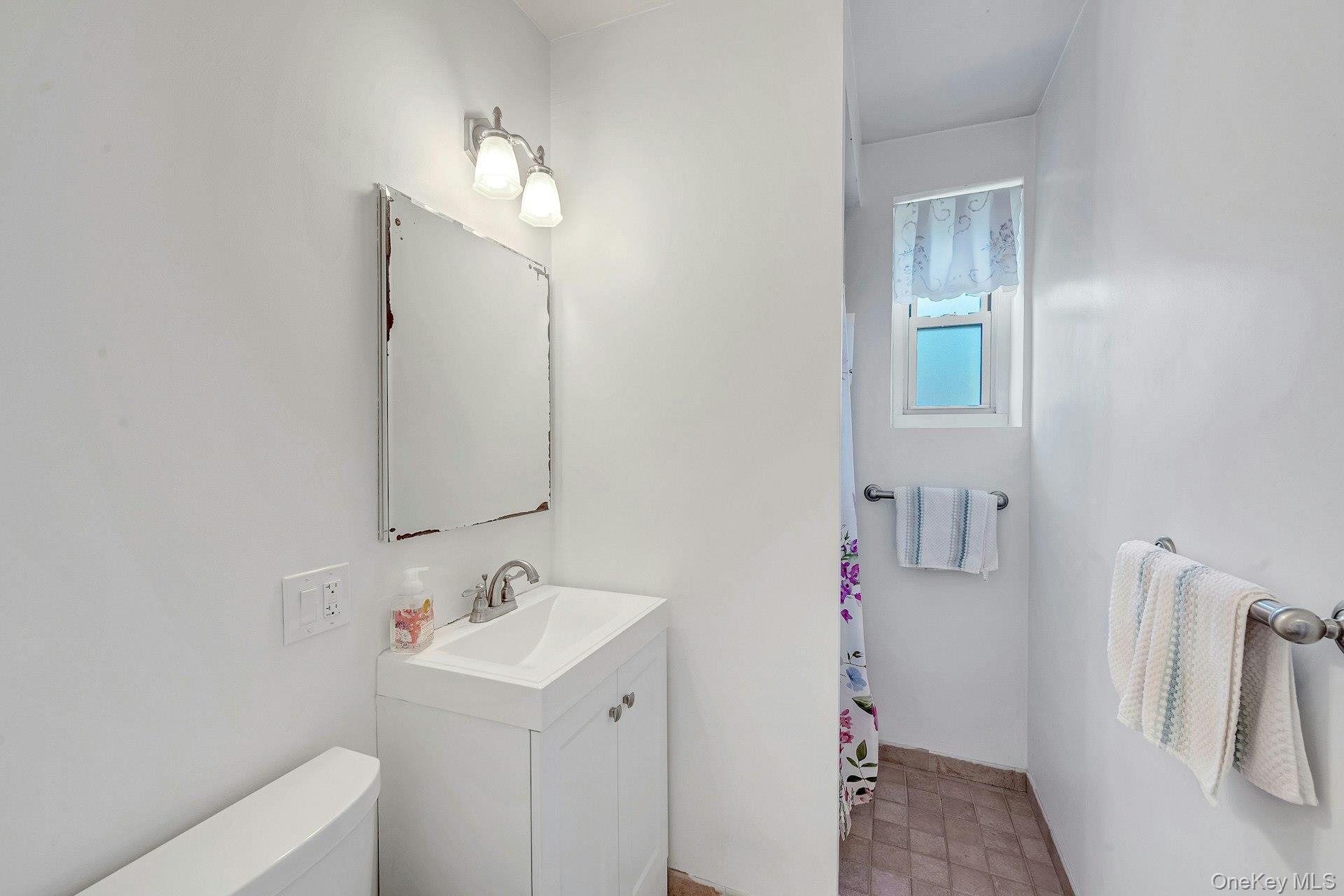 3 Midland Gardens, Unit 3H Bronxville, NY 10708 - Photo 17 of 20 a bathroom with a sink vanity and a mirror