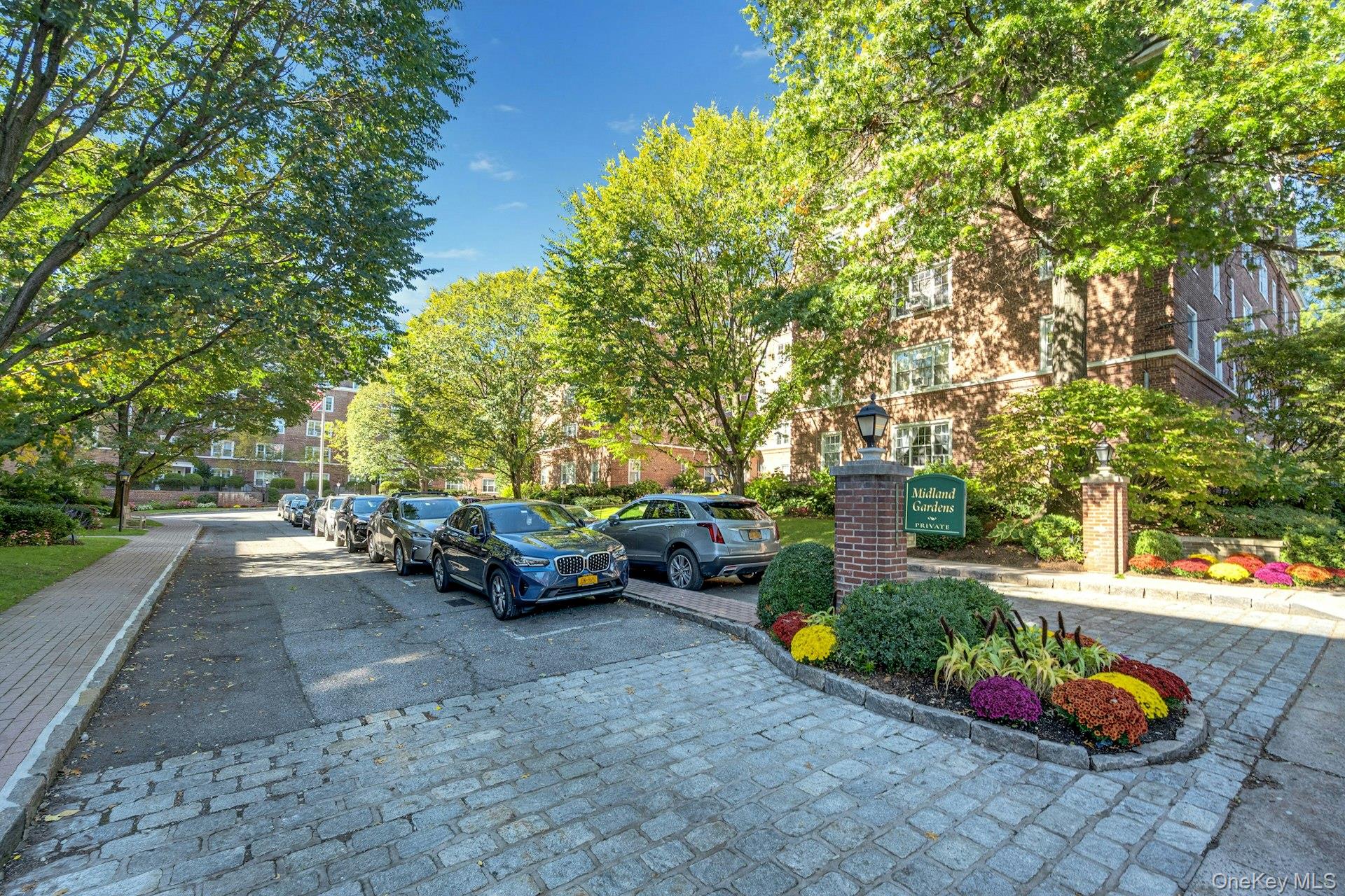 3 Midland Gardens, Unit 3H Bronxville, NY 10708 - Photo 19 of 20 a view of a backyard with table and chairs plants and trees