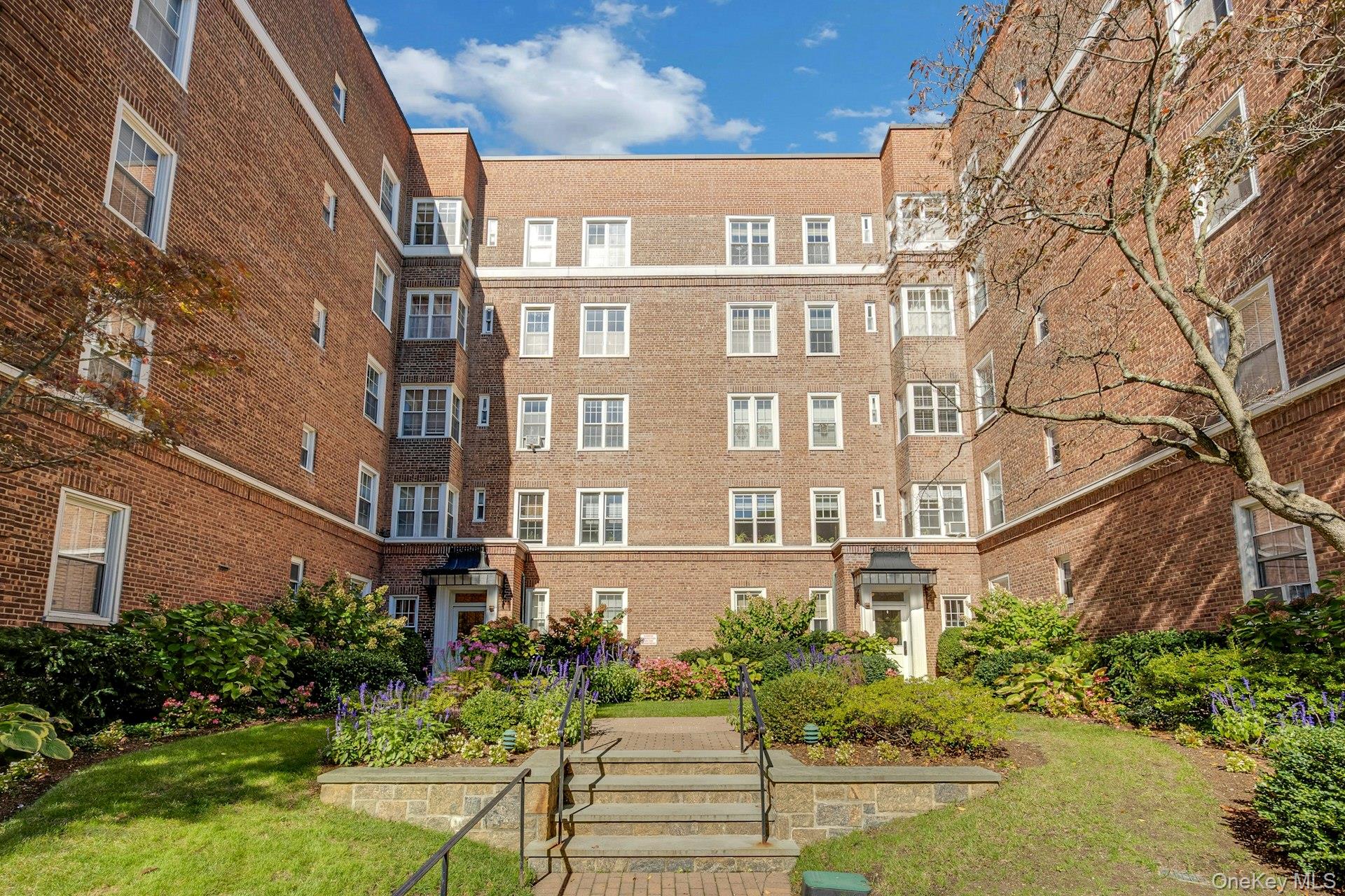 3 Midland Gardens, Unit 3H Bronxville, NY 10708 - Photo 2 of 20 a front view of a multi story residential apartment building with yard and parking