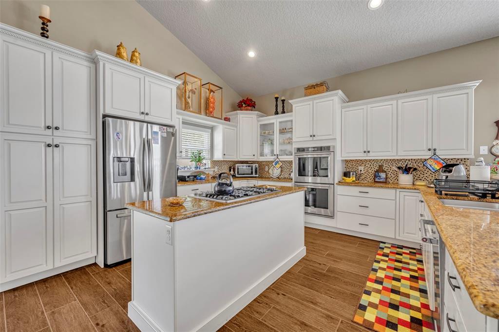 1134 Kelso Boulevard Windermere, FL 34786 - Photo 11 of 37 a kitchen with stainless steel appliances granite countertop a refrigerator and a stove top oven