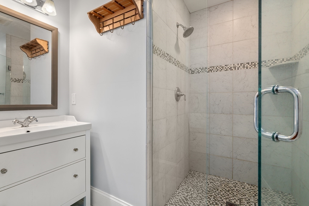 20 Manor Avenue Wellesley, MA 02482 - Photo 23 of 32 a bathroom with a shower sink and mirror
