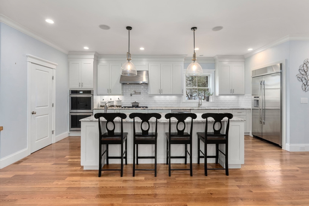 20 Manor Avenue Wellesley, MA 02482 - Photo 3 of 32 a kitchen with kitchen island granite countertop a dining table chairs and wooden floor
