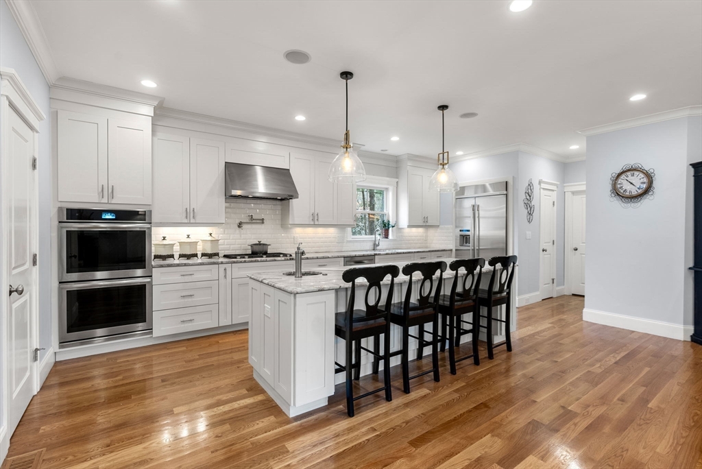 20 Manor Avenue Wellesley, MA 02482 - Photo 4 of 32 a kitchen with stainless steel appliances granite countertop a stove a sink a microwave a refrigerator and white cabinets with wooden floor