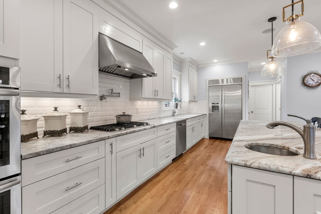 20 Manor Avenue Wellesley, MA 02482 - Photo 6 of 32 a kitchen with granite countertop white cabinets and white appliances