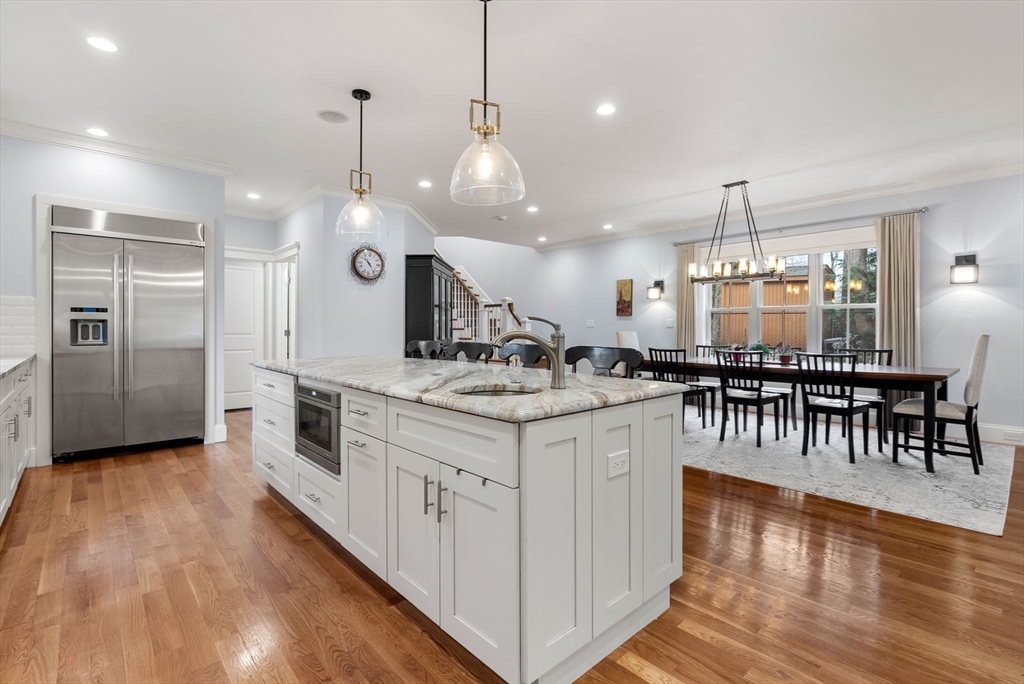 20 Manor Avenue Wellesley, MA 02482 - Photo 7 of 32 a kitchen with stainless steel appliances kitchen island granite countertop a stove a sink a refrigerator and a dining table with wooden floor