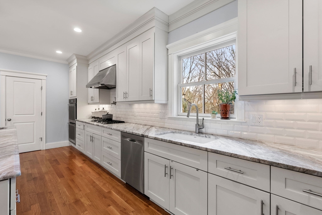 20 Manor Avenue Wellesley, MA 02482 - Photo 8 of 32 a kitchen with granite countertop white cabinets and wooden floor