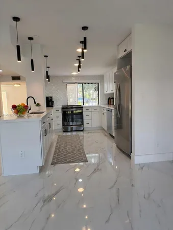 a kitchen with a sink a stove and cabinets