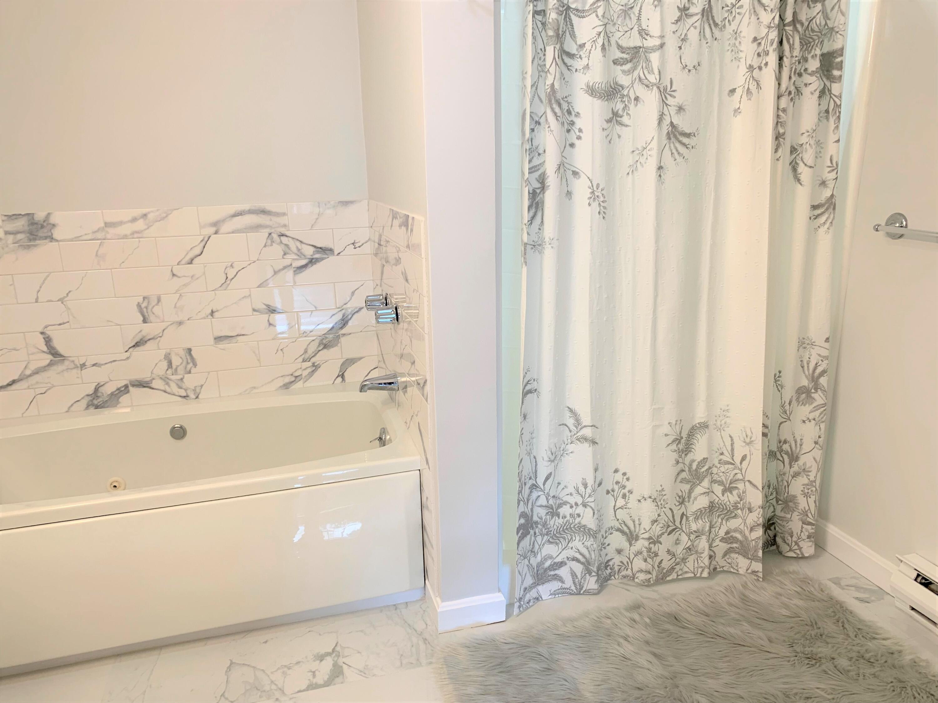 195 Falmouth Road, Unit 19D Mashpee, MA 02649 - Photo 13 of 17 a bathroom with a bathtub and shower