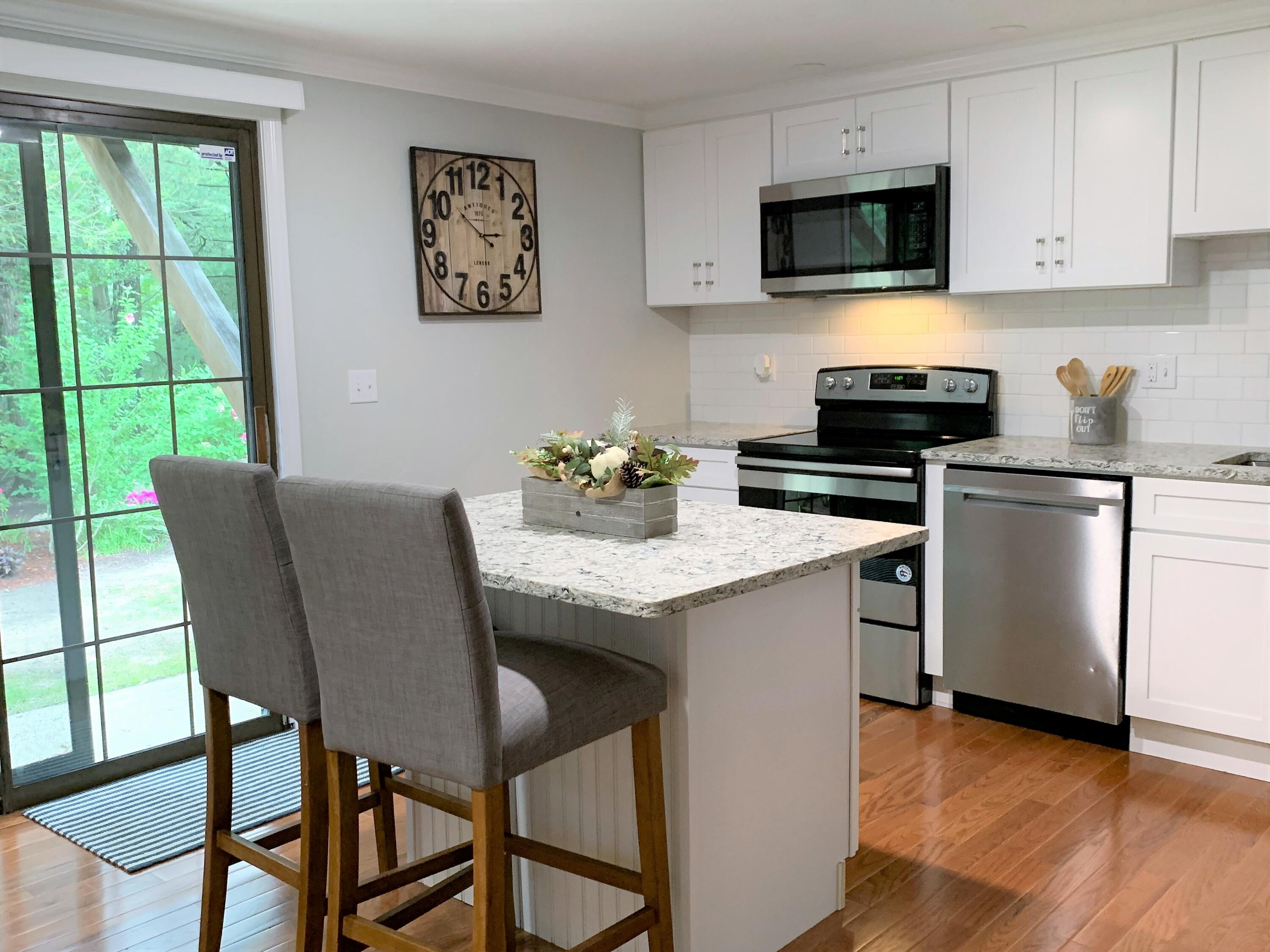 195 Falmouth Road, Unit 19D Mashpee, MA 02649 - Photo 6 of 17 a kitchen with a stove a sink and a microwave