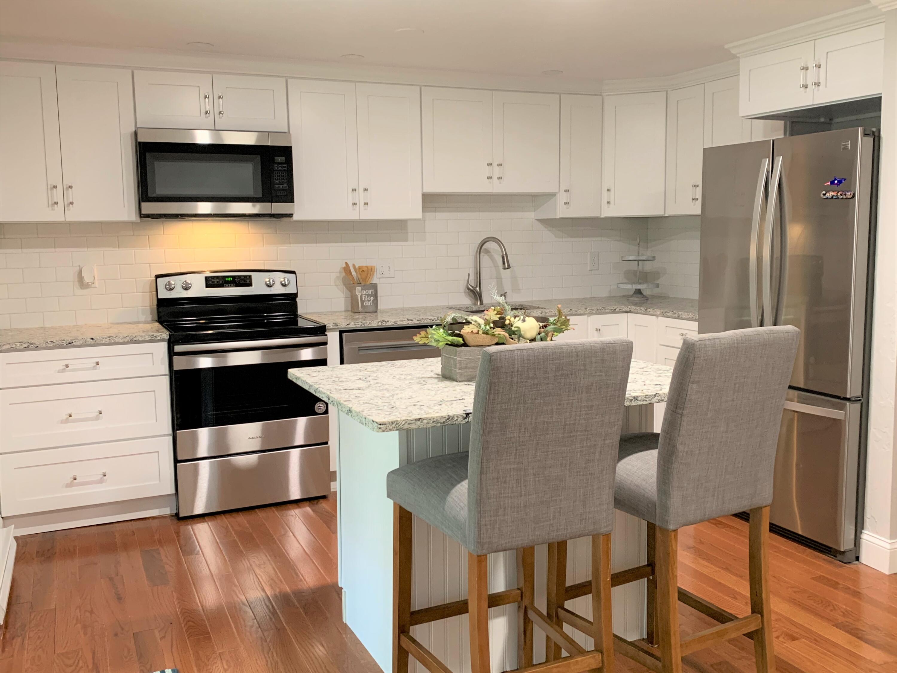 195 Falmouth Road, Unit 19D Mashpee, MA 02649 - Photo 7 of 17 a kitchen with stainless steel appliances a stove a sink island and a refrigerator