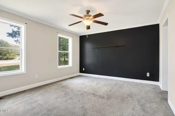 an empty room with windows and ceiling fan