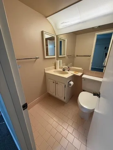 a bathroom with a toilet sink and mirror