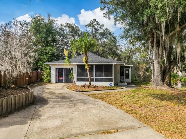 a front view of a house with a garden and trees