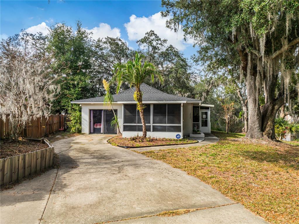 a front view of a house with a garden and trees