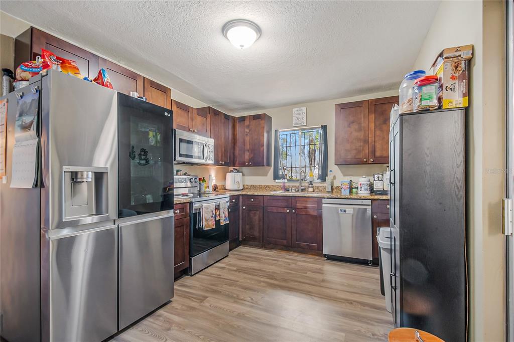 4432 Watch Hill Road Orlando, FL 32808 - Photo 14 of 30 a kitchen with granite countertop stainless steel appliances a refrigerator and a refrigerator