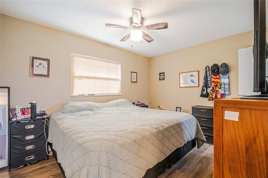 4432 Watch Hill Road Orlando, FL 32808 - Photo 18 of 30 a bedroom with a bed and a chandelier