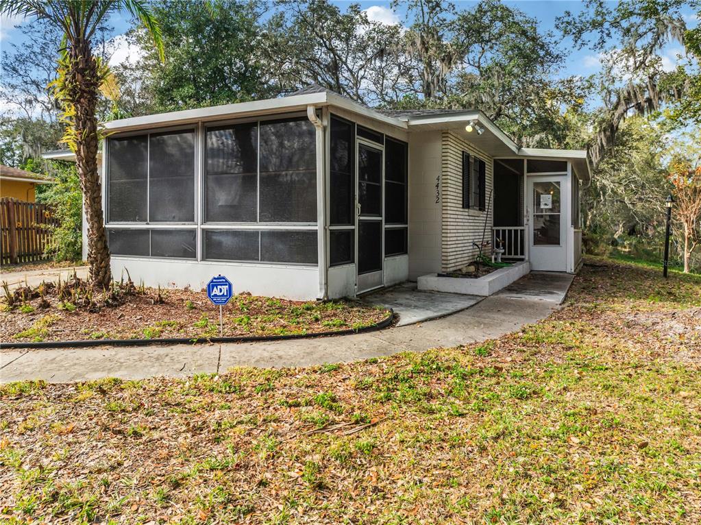 4432 Watch Hill Road Orlando, FL 32808 - Photo 2 of 30 a front view of a house with a garden and yard