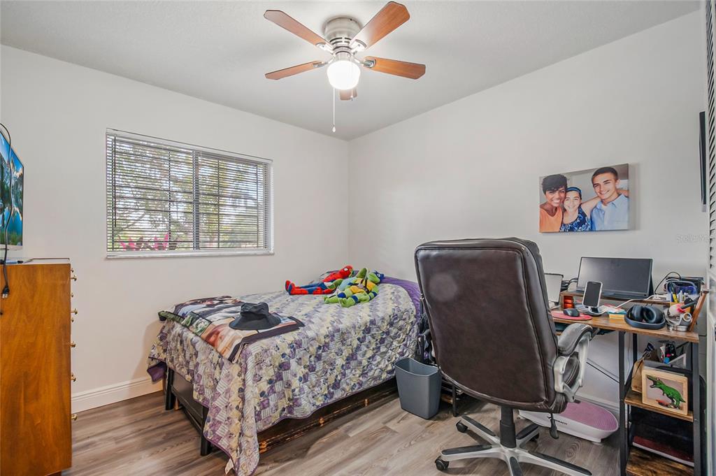 4432 Watch Hill Road Orlando, FL 32808 - Photo 23 of 30 a bedroom with a bed and a desk