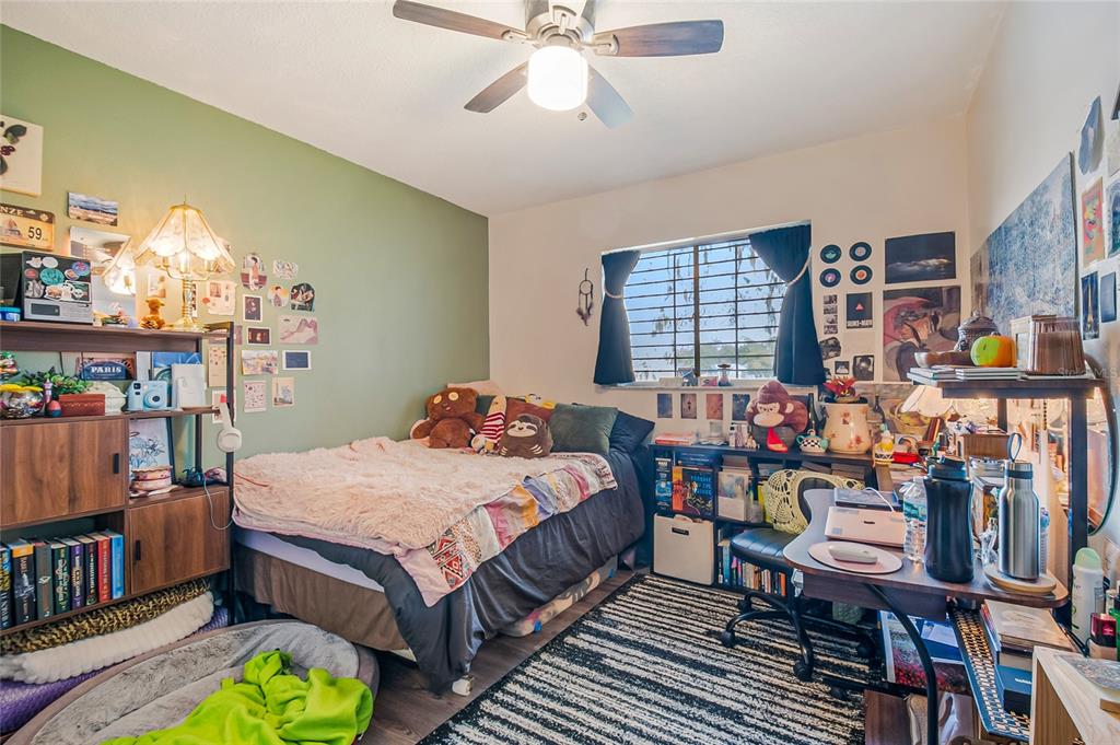 4432 Watch Hill Road Orlando, FL 32808 - Photo 25 of 30 a bedroom with a bed table and a window