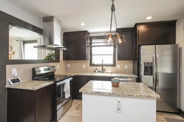 a kitchen with stainless steel appliances granite countertop a sink refrigerator and microwave
