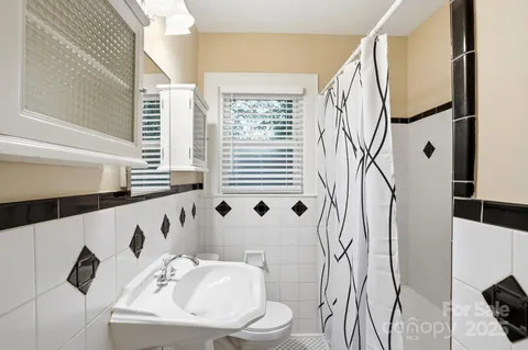 a bathroom with a sink and mirror with bathtub